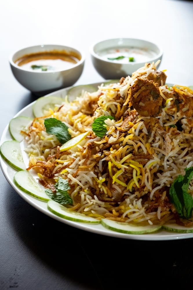 Hyderabadi-style chicken biryani garnished with mint and cucumber
