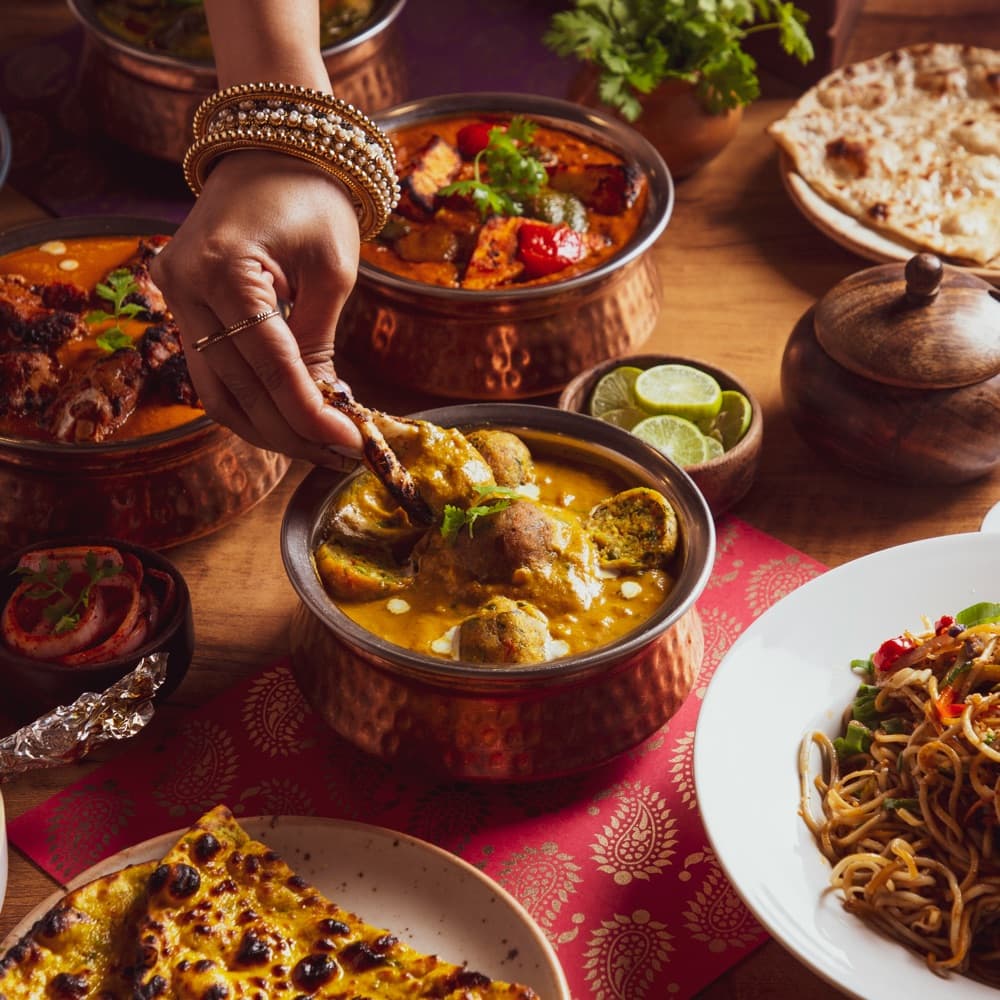Indian wedding catering spread with chicken, paneer tikka, naan, and noodles
